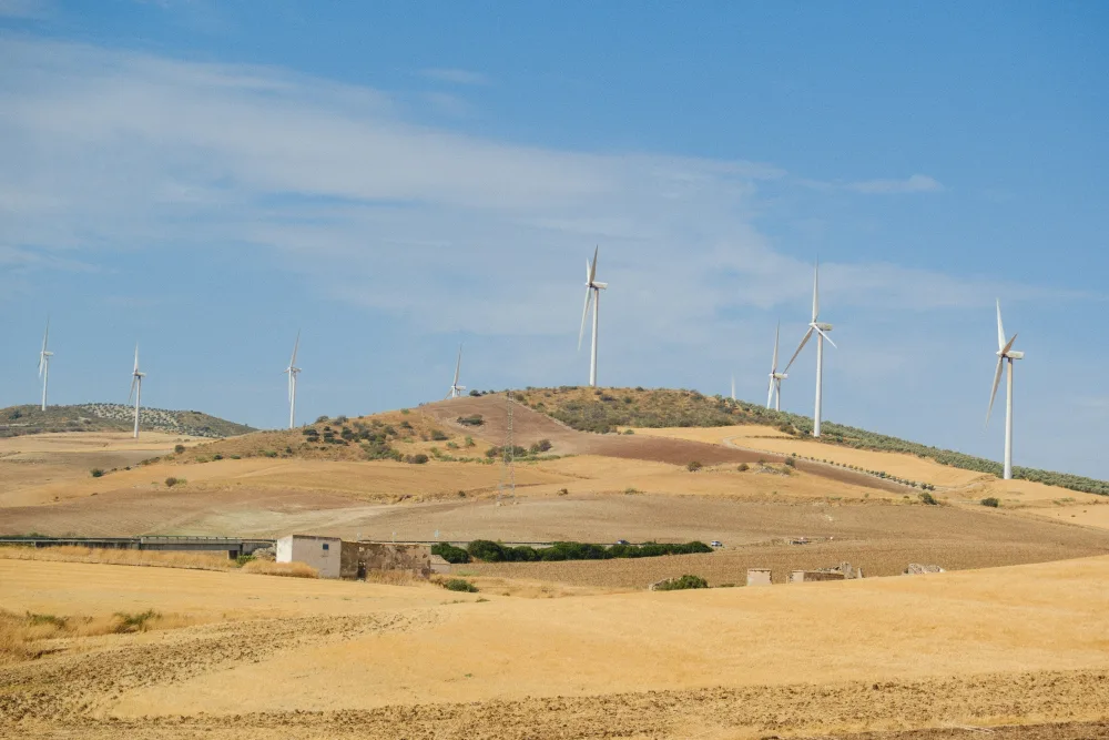 Wind turbines across a dry, rolling landscape, illustrating wind generation